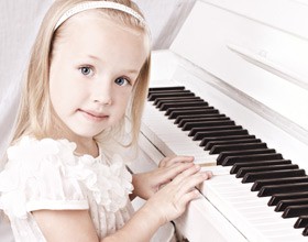Girl in white playing white piano